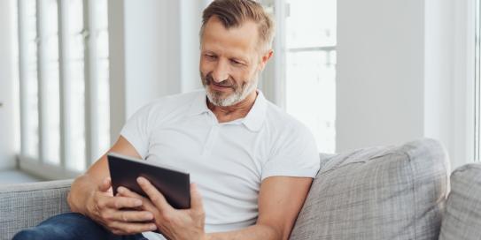 Mann mit Tablet auf einem Sofa
